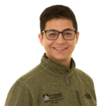 Man with dark hair and glasses smiling at the camera.