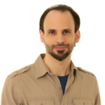 Man with dark hair and beard smiling at the camera.