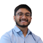 Man with dark hair and glasses smiling at the camera